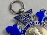 an image of a blue and silver medal with a picture of a man on it