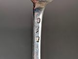 a silver spoon with a silver handle on a table