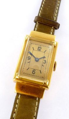 an image of a gold plated wrist watch with a brown leather strap