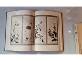 an open book with a picture of flowers and birds on it