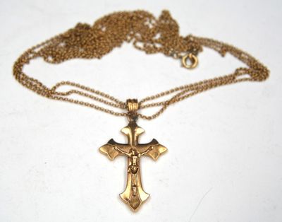 a close up of a cross on a chain on a table