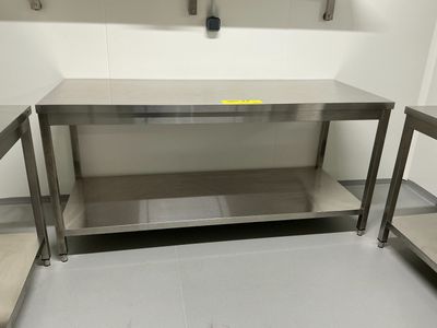 une table de travail en acier inoxydable dans une cuisine, avec deux chaises