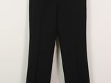 un pantalon noir accroché à un mur blanc
