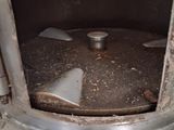 a dirty stove with a metal burner in the middle of it