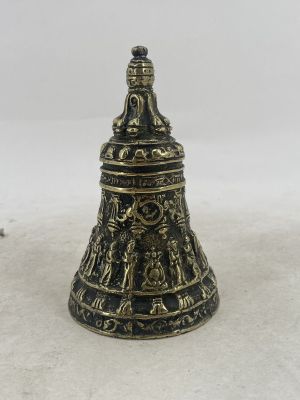a brass bell with a black and gold design on it