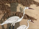 two birds that are standing on a rug together