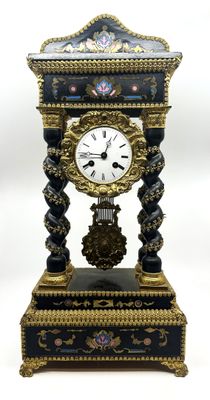 une horloge noire et or posée sur une table