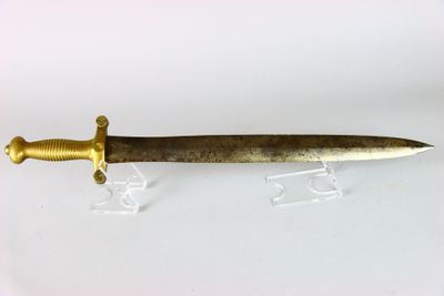 une vieille dague au manche doré, posée sur un socle transparent