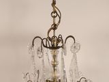 an antique brass chandelier with crystal drops hanging from the ceiling