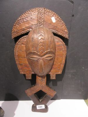 a wooden mask that is on display on a table