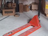 un cariste dans un garage, avec des cartons en arrière-plan