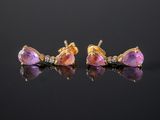 a pair of pink sapphire and diamond earrings on a black surface