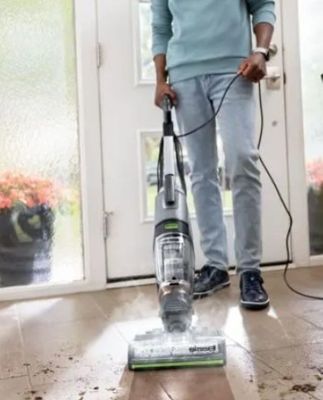 un homme qui passe l'aspirateur pour nettoyer le sol