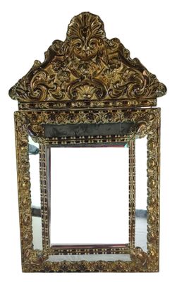 mirror with ornate design on top of it on a white surface