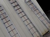 two ladders that are leaning up against a building