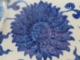 a close up of a blue and white plate with flowers on it