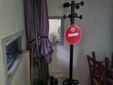 a room with a table, chairs, and a sign on the wall