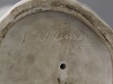 a close up of a white vase with writing on it