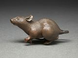 bronze figurine of a mouse with horns on a gray surface