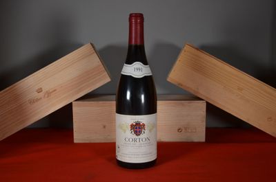 une bouteille de vin posée sur une table, à côté de deux caisses en bois