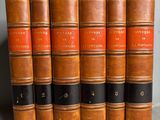 six vieux livres sont alignés sur une table