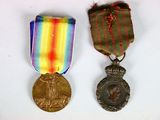 deux médailles et une médaille sur une surface blanche