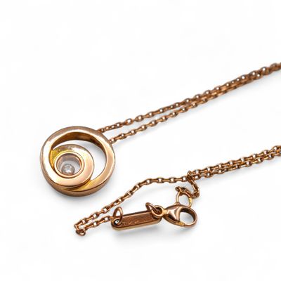 necklace with a gold chain and a diamond on a white background