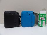 two cameras sitting next to each other on a table