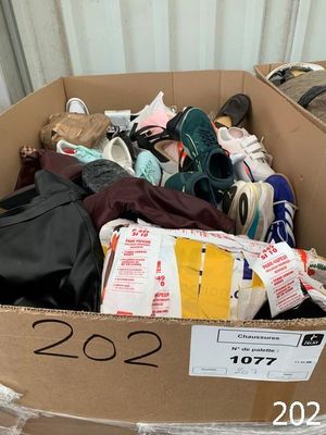 a cardboard box full of shoes and other items in it