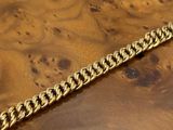a close up of a wooden table with a gold chain on it