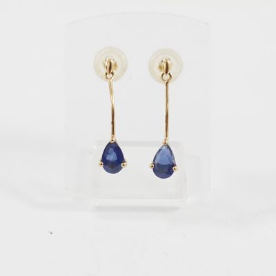une paire de boucles d'oreilles en saphir bleu présentée dans un écrin transparent