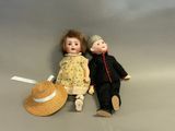 two dolls sitting next to each other on the floor