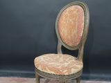 an old chair with a pink and gold upholstered seat