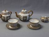 a tea set with a cup and saucer on the table
