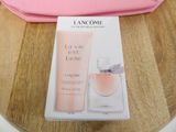 packaging of lancomme la vie belle eau de toilette next to a pink bag on a wooden table