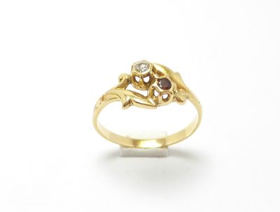un gros plan d'une bague en or sertie d'un diamant et d'une pierre rouge