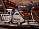 a brown motorcycle parked in front of a brick wall