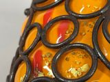 a close up of a yellow vase with black rings on it