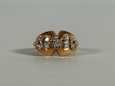 a close up of a gold ring with diamonds on a white surface