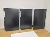 three black and white monitors sitting on top of a wooden table