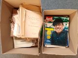 une boîte remplie de livres et de magazines posée par terre