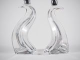 pair of clear glass swan salt and pepper shakers on white background