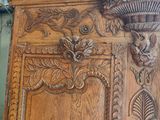 a wooden cabinet with carvings on it in a room