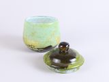 a small bowl with a lid sitting next to a smaller bowl