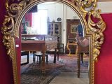 un grand miroir doré dans un coin de la pièce