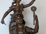 bronze statue of a man and woman sitting on a chair