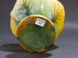 a green and yellow vase with a label on it