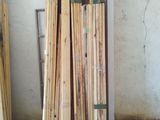 Plusieurs morceaux de bois sont empilés sur le sol dans une pièce.