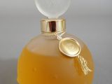 yellow perfume bottle with a gold lid and a white cap