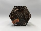 une image représentant un objet octogonal noir et doré muni d'un bracelet en cuir